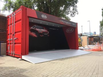 Bespoke shipping container conversion for Kia Cars Stinger paint finished in brand red with internal graphics, set up on location.